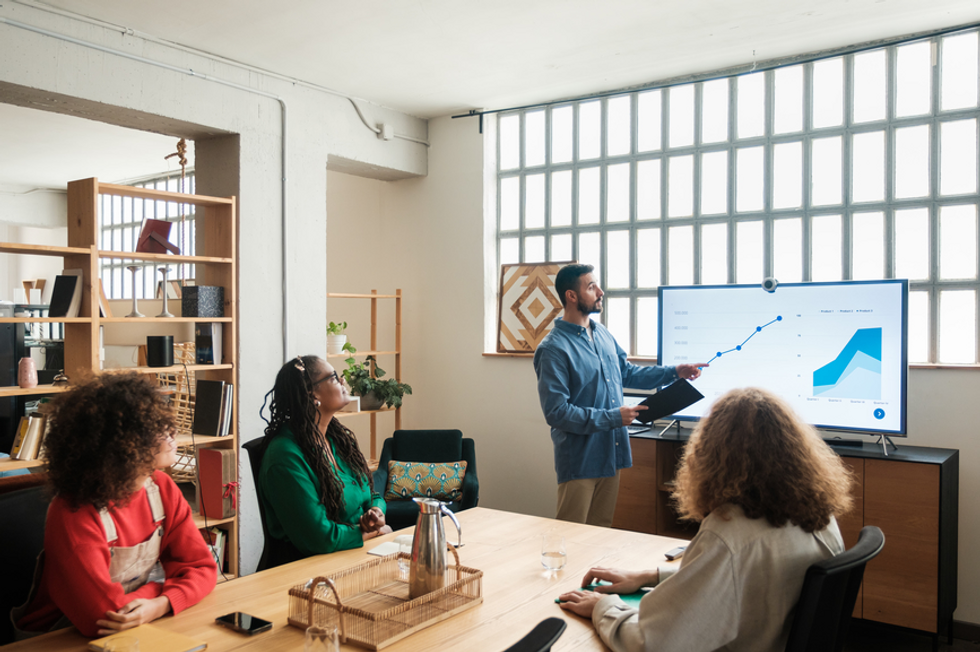 A manager showing some business forecasting tools to his employees. 